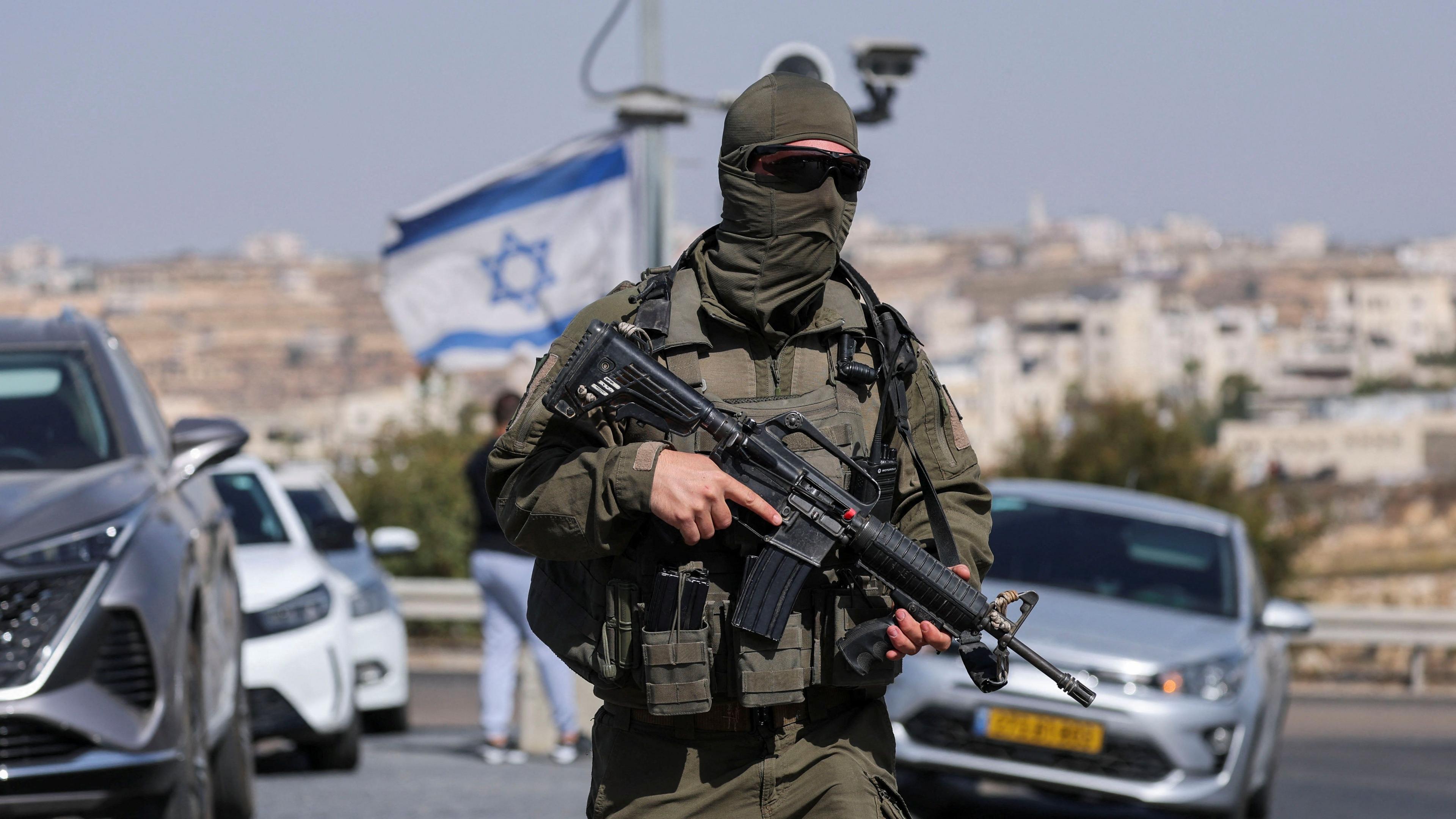 A masked Israeli soldier holds a gun