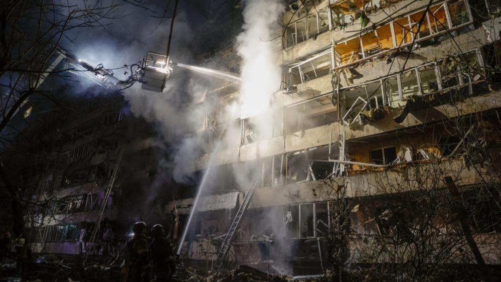 Ukrainian rescuers work at the site of a Russian air strike on a residential building in Kyiv