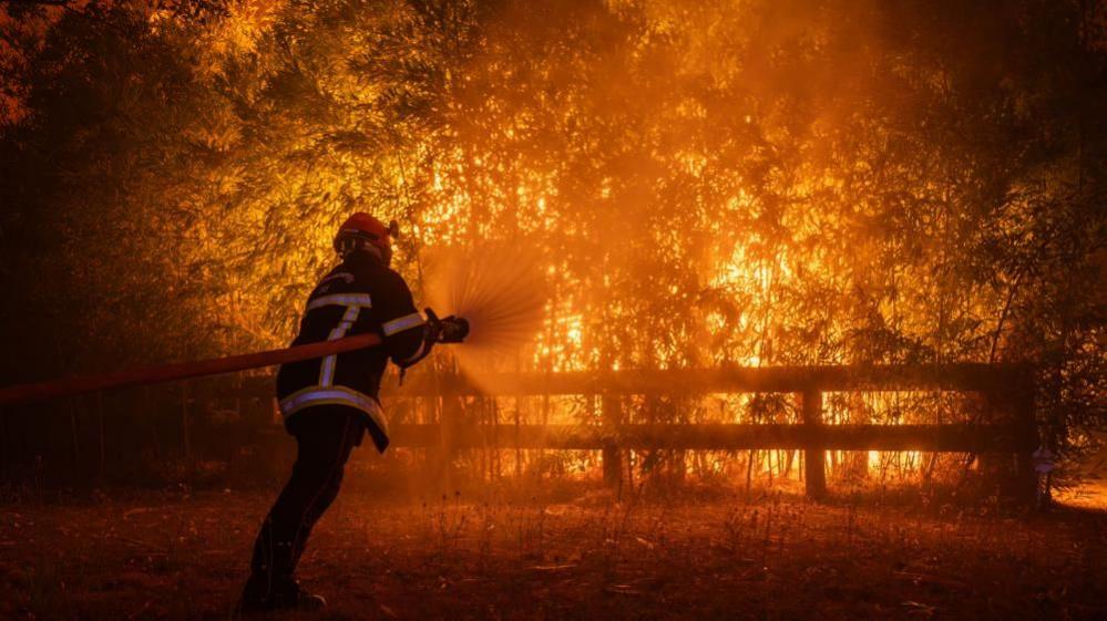 Firefighter battling flames in Ares, France