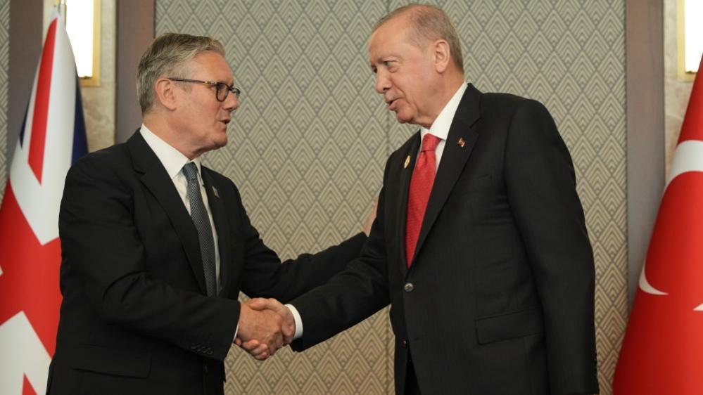 Turkish President Gaves UK PM a Live Revolver at NATO Summit