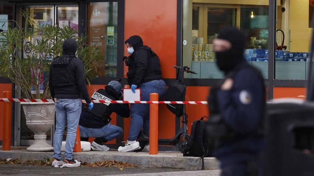 French police inspect the scene of the shooting in Trappes near Paris